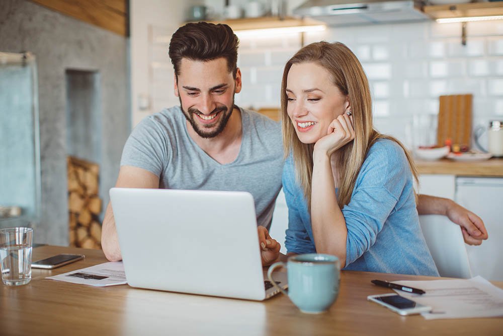 Couple sitting and looking at laptop