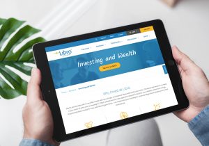 Hands holding a tablet showing the Libro website