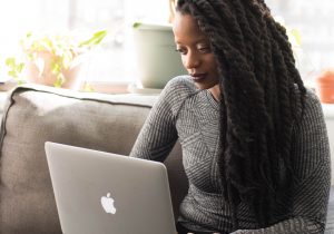 Libro owner sits on coach typing on a laptop