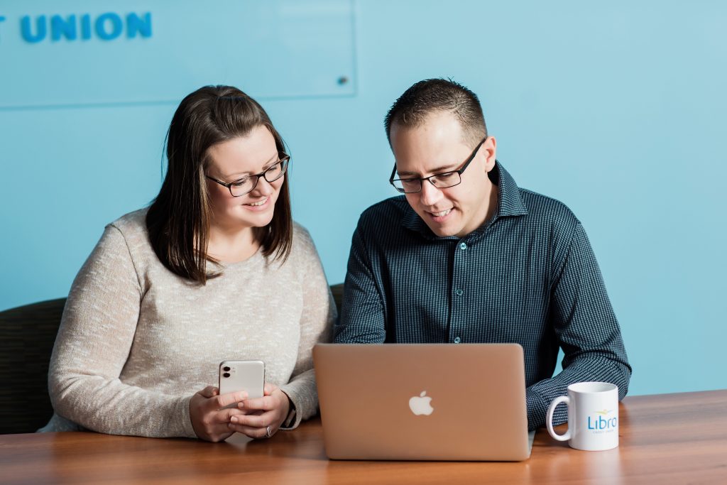 Couple smiling looking at laptop