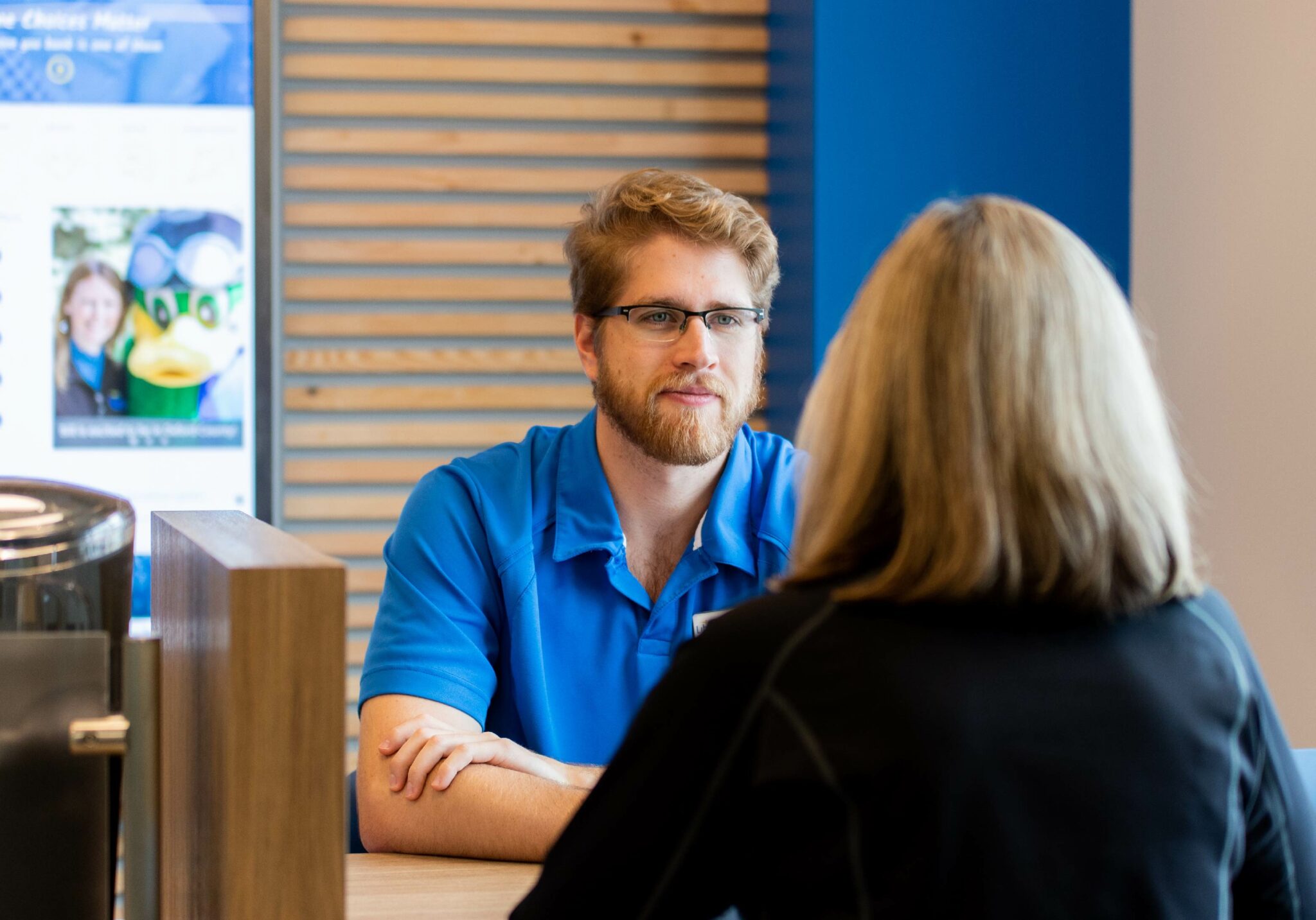 Libro employee at desk spekaing to customer