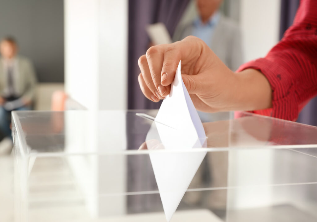 Hand putting vote in ballot box