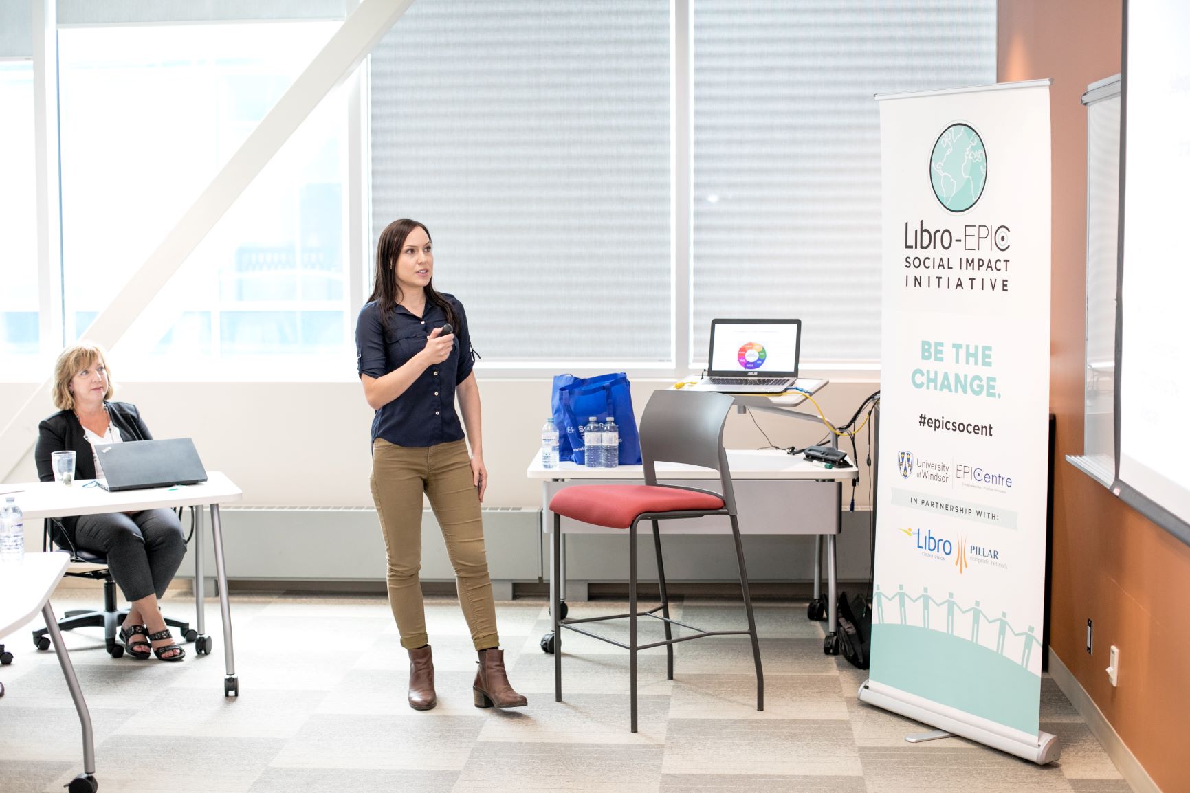 A person standing presenting in the front of a classroom