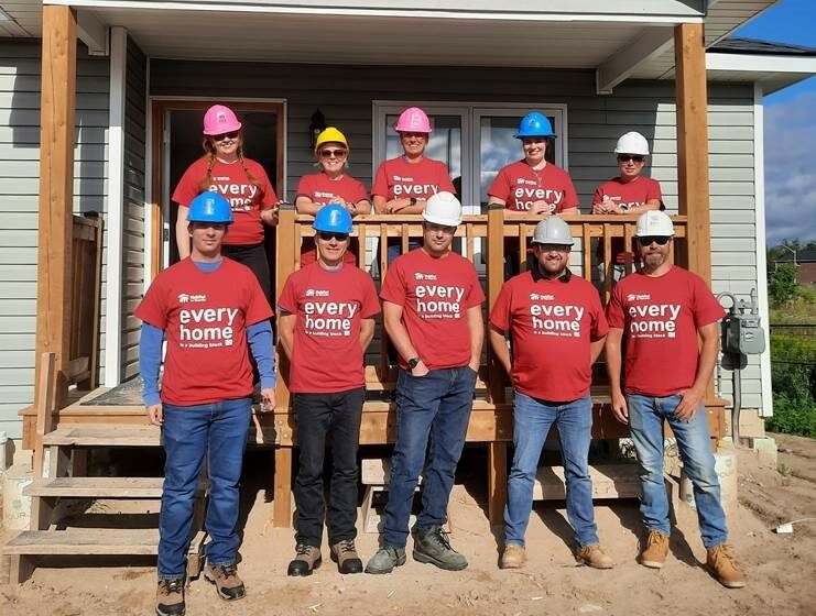 Group photo of Libro employees standing in front of a Habitat for Humanity build