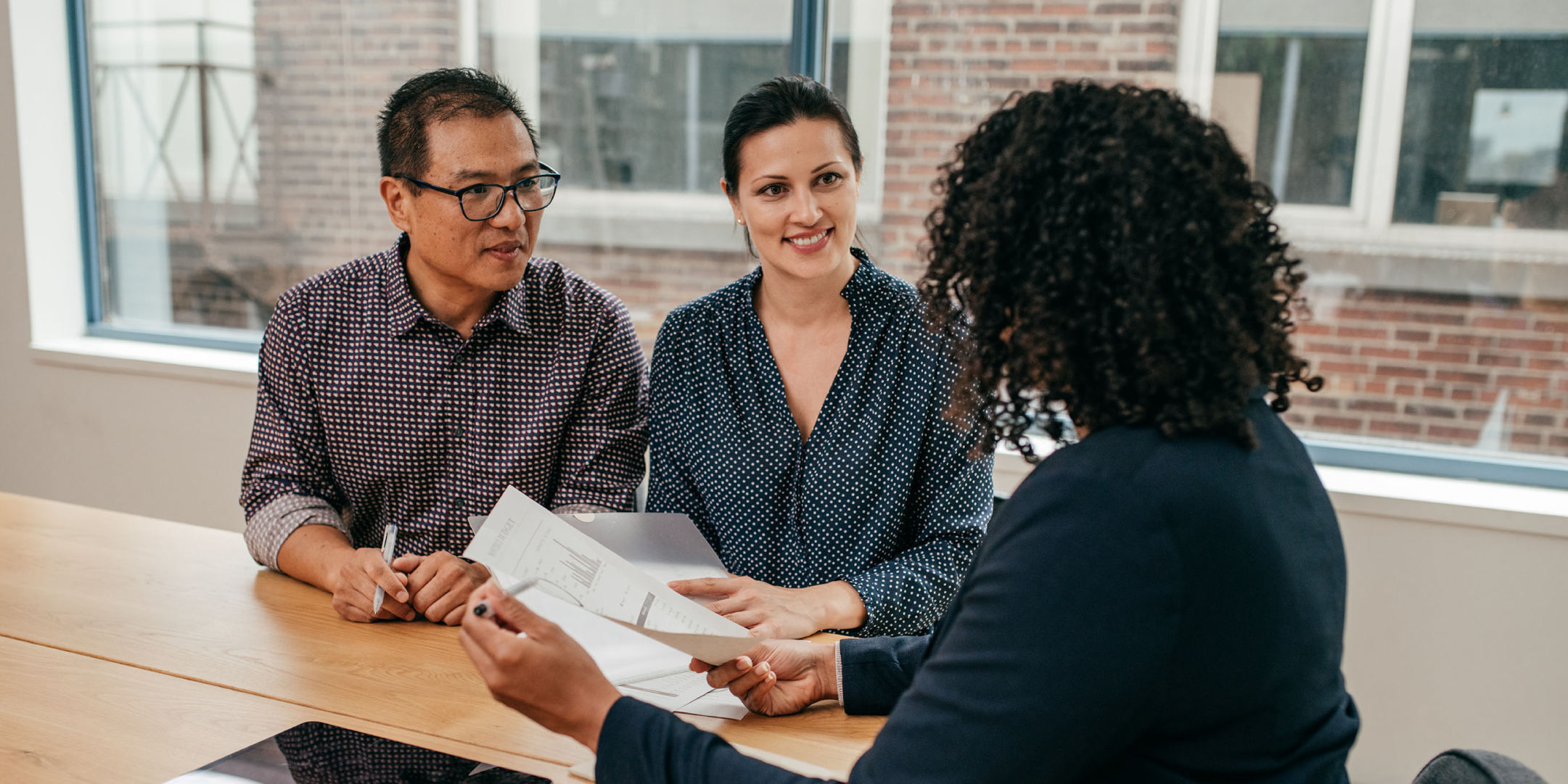 Man and woman at desk talking to financial advisor