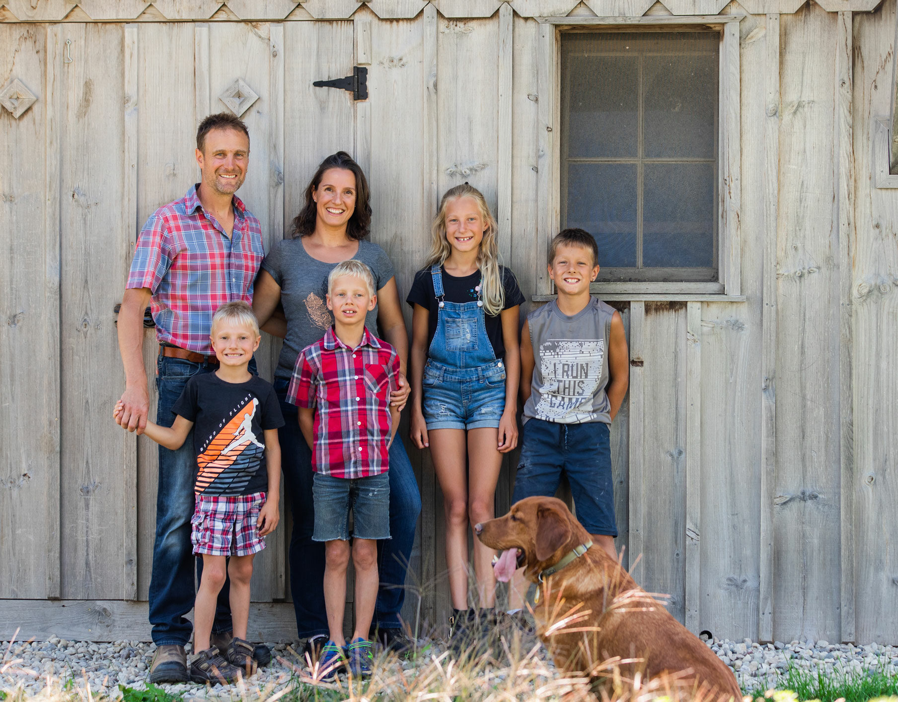 Libro Members at their farm standing in front of a barn