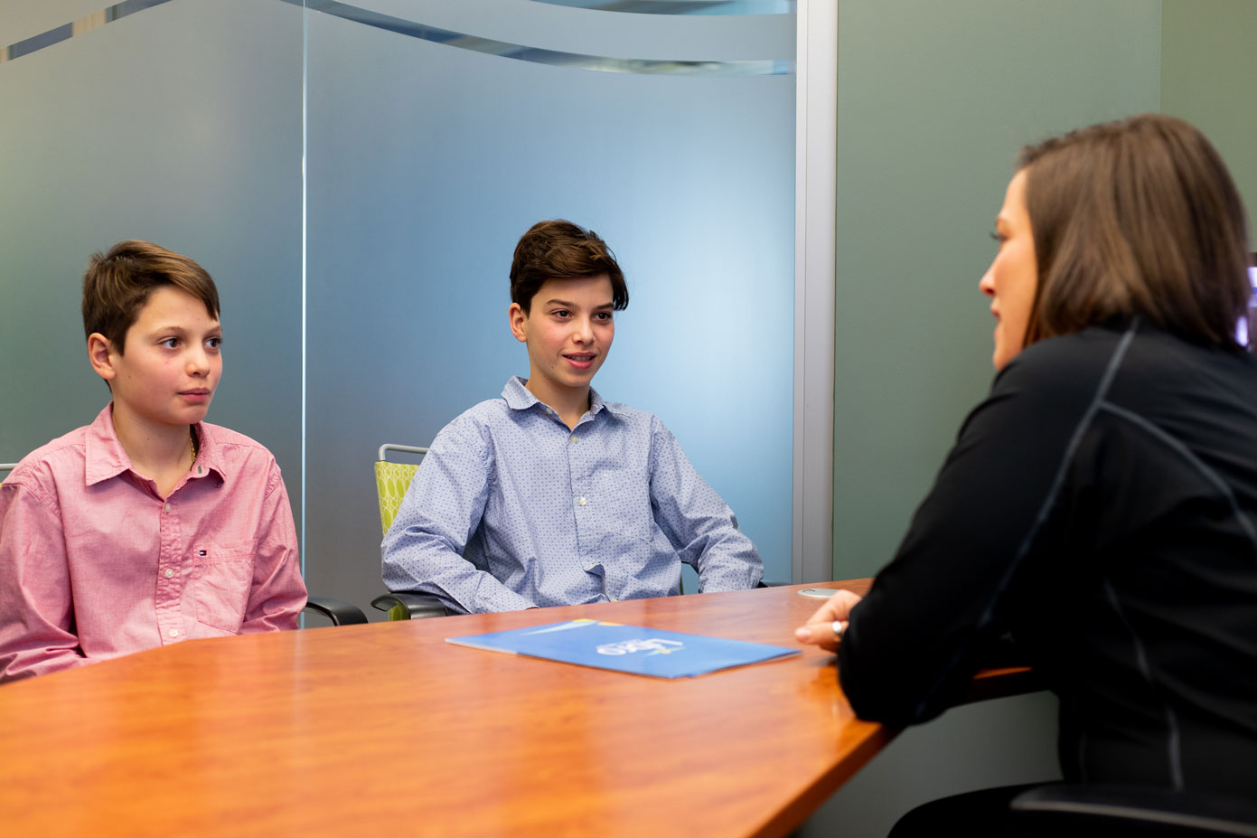 Libro Coach talking in office with two young boys
