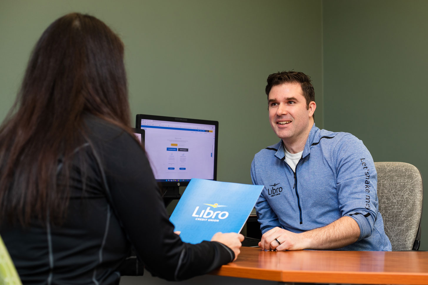 Libro Staff member talking to a Libro Member sitting at a desk