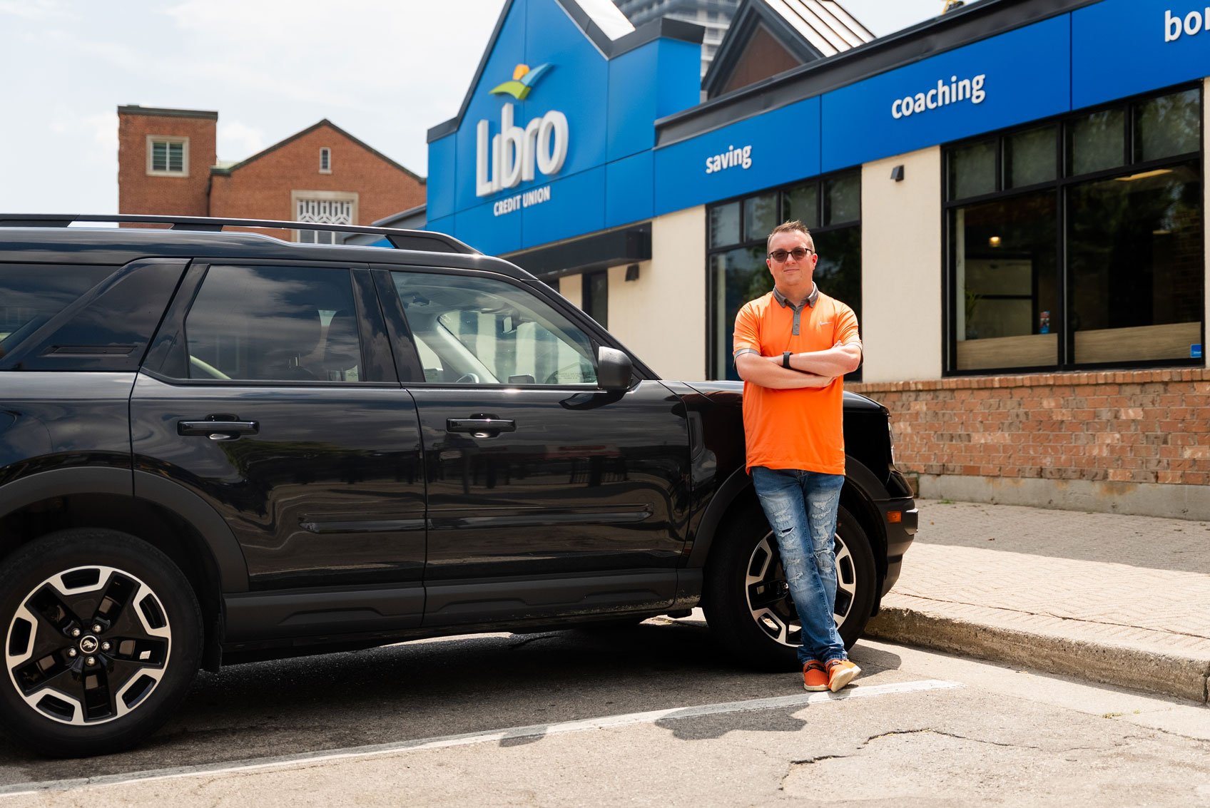 Libro Member, Dan standing next to a car outside of a Libro branch