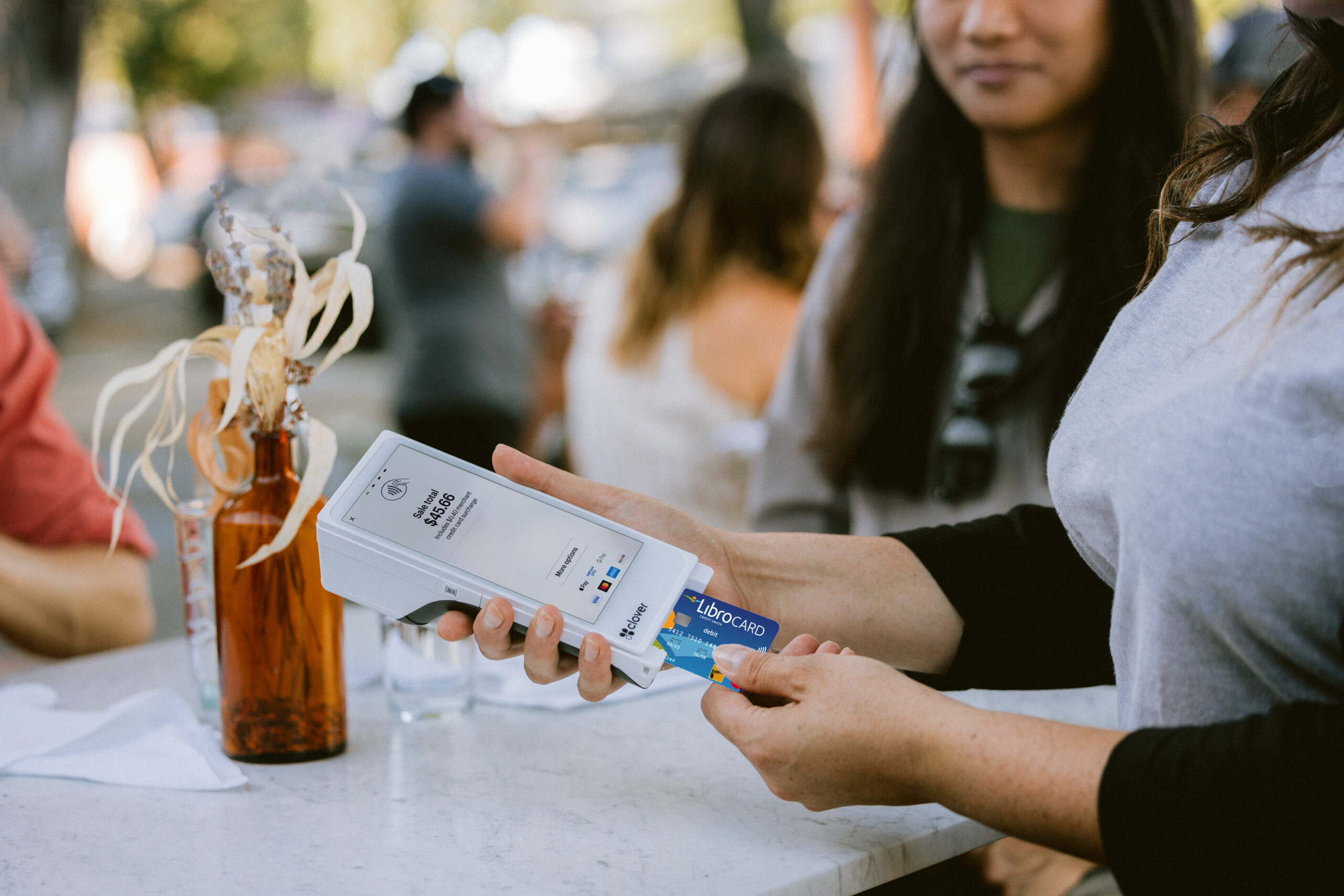 Woman inserting her Libro debit Mastercard into a Clover machine