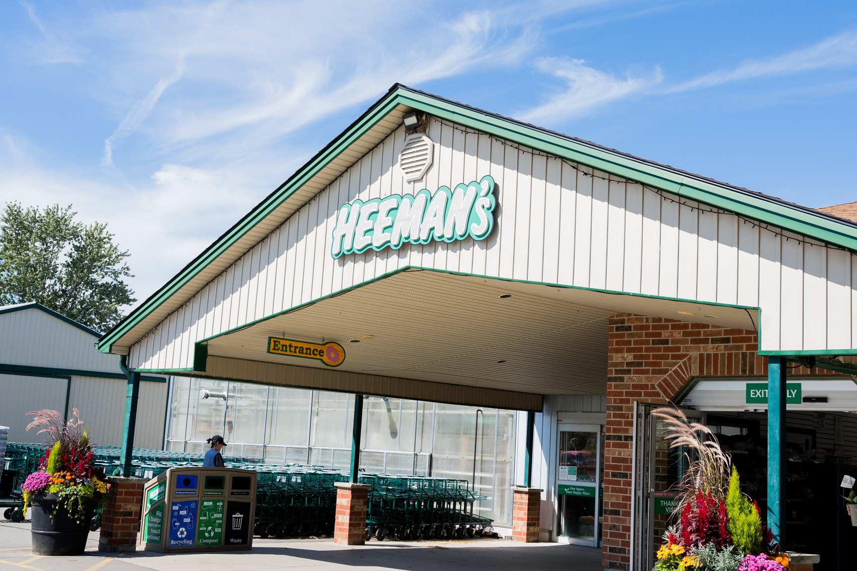 Entrance to Heeman’s garden center with a row of shopping carts and a recycling station.
